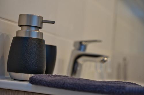 a black soap dispenser on a counter in a bathroom at MátraForRest in Mátraszentistván