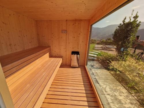 a sauna with wooden floors and a large window at Videre Penthouse Lodge exclusive in Gargazzone
