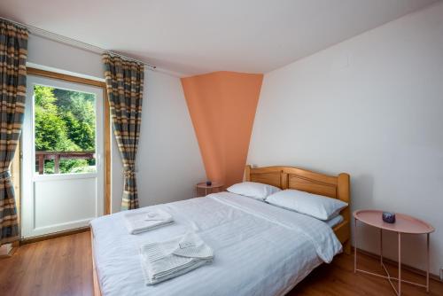 sypialnia z łóżkiem i dużym oknem w obiekcie Oasis Mountain Villa w Braszowie