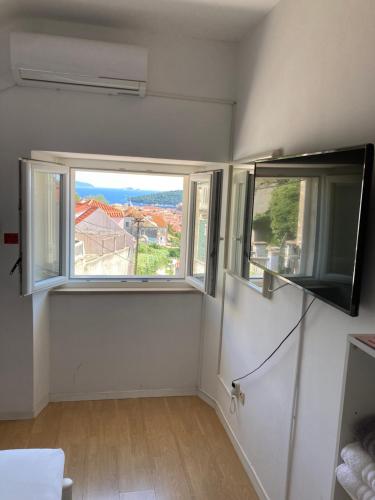 a living room with two windows and a television at guesthouse Libertas 3 in Dubrovnik