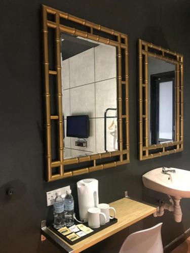 baño con espejo y lavabo en Kavy Boutique Hotel @ KBH, en Brinchang