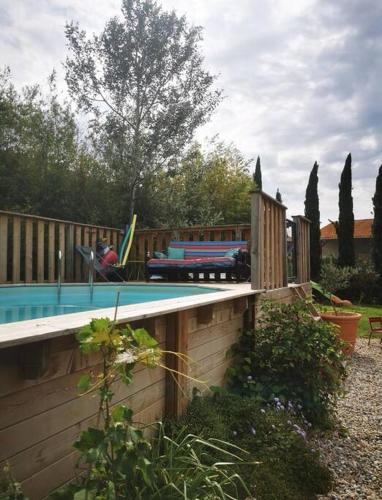 une cour avec une piscine et une clôture en bois dans l'établissement Maison avec piscine dans village provençal., à Courthézon