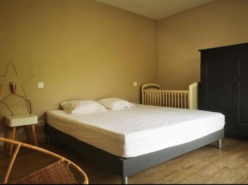 une chambre avec un grand lit avec des draps blancs dans l'établissement Maison avec piscine dans village provençal., à Courthézon