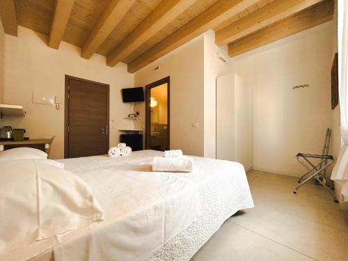 - une chambre avec un lit blanc et des serviettes dans l'établissement Via Poma Rooms, à Vérone