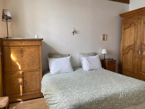 une chambre avec un lit et une commode en bois dans l'établissement Le Clos Saint Guilhem, à Gerzat