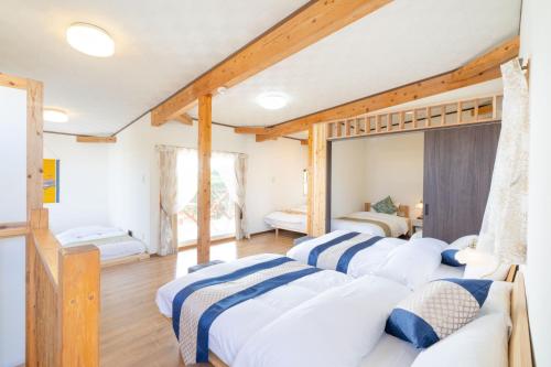 3 camas num quarto com tectos em madeira em Me-fi-You Ishigaki Island - Vacation STAY 95379 em Ishigaki