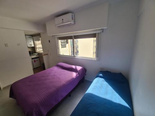 1 dormitorio con 2 camas y ventana en Av. Corrientes 1670 - Paseo La Plaza - en Buenos Aires