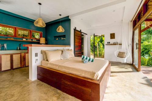a bedroom with a large bed in a room with blue walls at The River Hideaway in General Luna