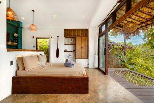 a bedroom with a bed and a large window at The River Hideaway in General Luna