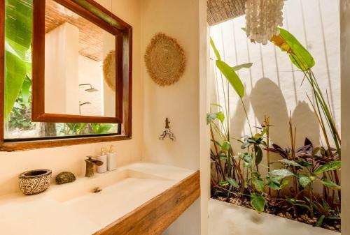 baño con lavabo y ventana con plantas en The River Hideaway en General Luna