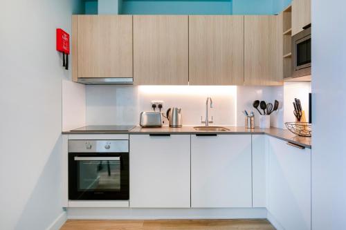 a kitchen with white cabinets and a sink at Coleman Court Summer Accommodation in Cork