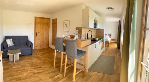 a kitchen and a living room with a couch at Biohof-Feichtinger in Zell am Moos