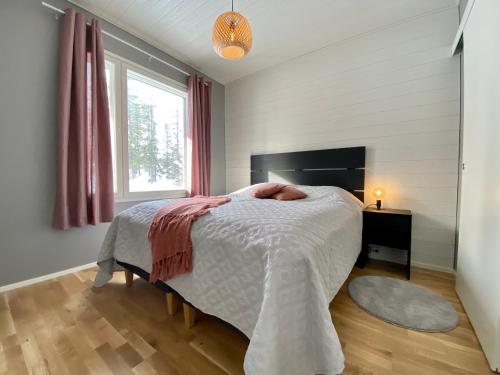 a bedroom with a bed and a window at Holiday homes Ruka in Ruka