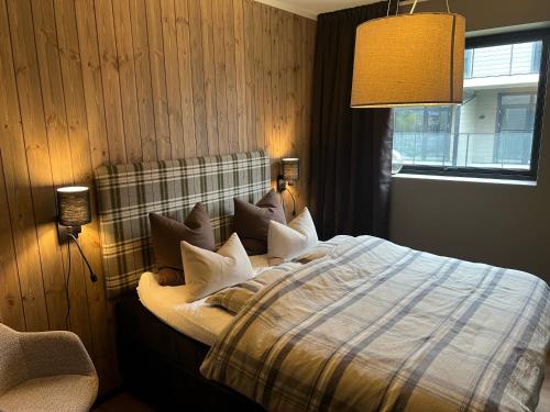 una camera da letto con letto, cuscini e finestra di Ny leilighet, 2023, sentral beliggenhet ved Highland a Geilo