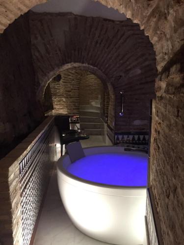 a bath tub in a room with a brick wall at Pintor El Greco in Toledo