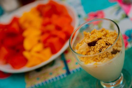 a glass of milk next to a plate of fruit at Hotel Flamingos Inn in Chuburná