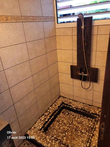bagno con doccia e pavimento in ciottoli di ENTRE DEUX HOTES a Entre-Deux