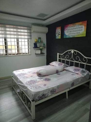 ein Schlafzimmer mit einem Bett mit einem weißen Bettrahmen in der Unterkunft Mom's home in Pasir Gudang