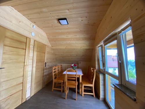 a wooden dining room with a table and chairs at Apartamenty Arkadia Jaworzynka - Zapasieki in Jaworzynka