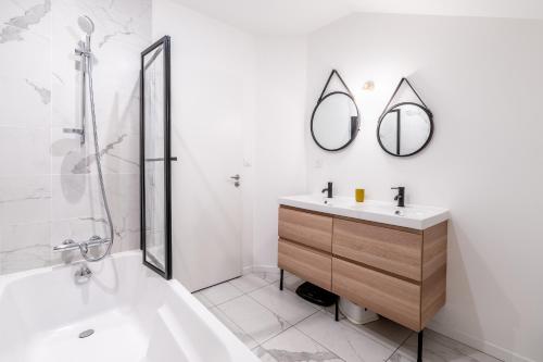 une salle de bain avec un lavabo, une douche et un miroir dans l'établissement Maison à 15min du centre ville Nantes - Un Air de Vacances, à Orvault