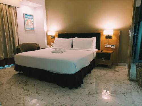 a hotel room with a large bed and a desk at Holiday Inn Dar Es Salaam by IHG in Dar es Salaam