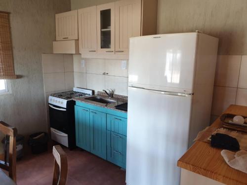 a kitchen with a white refrigerator and blue cabinets at La escondida in San Rafael