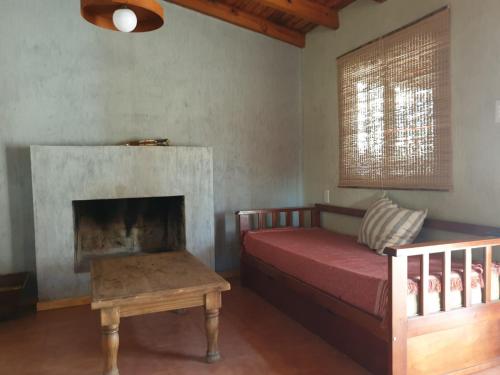a living room with a bed and a fireplace at La escondida in San Rafael