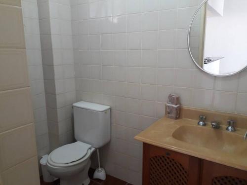 bagno con servizi igienici, lavandino e specchio di Apartamento 1 quarto Mongaguá a Mongaguá
