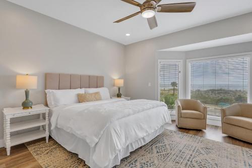 1 dormitorio blanco con 1 cama y ventilador de techo en Sunny Breeze, en Tybee Island