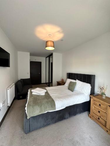 1 dormitorio con 1 cama grande y 1 sofá en Riverside Apartment, en Peterborough