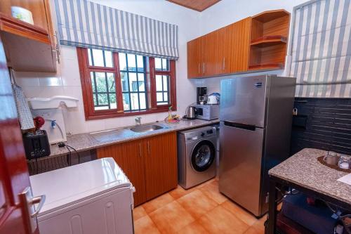 cocina con nevera de acero inoxidable y lavavajillas en Villa (2) Del Sol: Lakefront and Cruise Boat en Kisumu