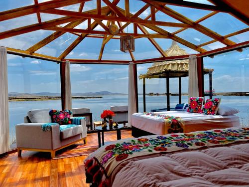 two beds in a room with a view of the water at Titicaca Ecolodge Perú in Puno