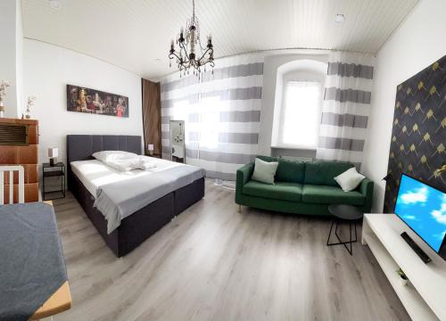 1 dormitorio con 1 cama y 1 sofá verde en Historisches Haus am Fuße der Festung Ehrenbreitstein am schönen Rhein, en Coblenza