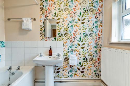 a bathroom with a sink and a shower curtain at Mill House Oxford in Oxford