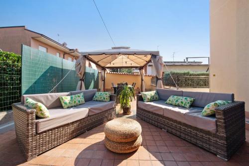 two wicker couches on a patio with an umbrella at Casa Elli in Osio Sotto