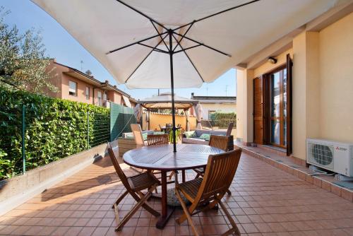 a table and chairs on a patio with an umbrella at Casa Elli in Osio Sotto