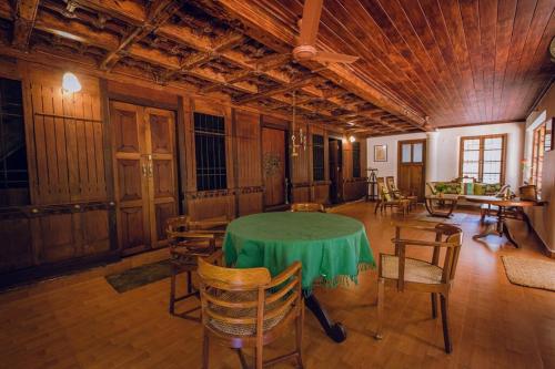 a large room with a green table and chairs at Meenachil Creek Homestay in Kottayam