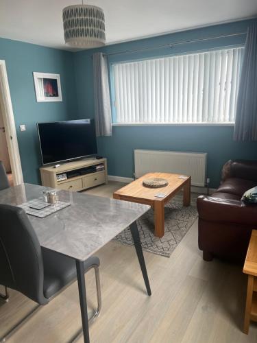 sala de estar con mesa y sofá en 'Kodi's Place' Well appointed 1 bedroom apartment with excellent transport links and free Wi-Fi, en Whiteabbey