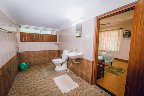 La salle de bains est pourvue de toilettes et d'un lavabo. dans l'établissement Meenachil Creek Homestay, à Kottayam