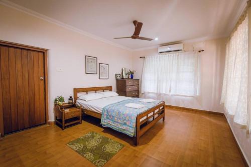 - une chambre avec un lit et un ventilateur de plafond dans l'établissement Meenachil Creek Homestay, à Kottayam