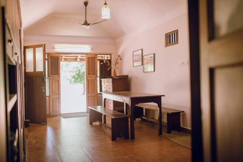 a room with a desk and a table in it at Meenachil Creek Homestay in Kottayam