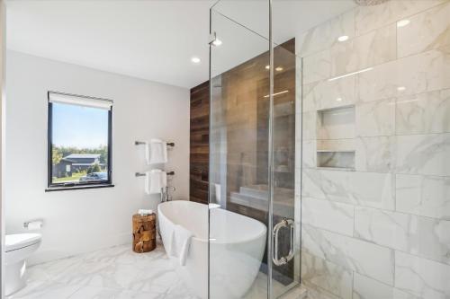een badkamer met een bad en een glazen douche bij Wildebrook in Stowe