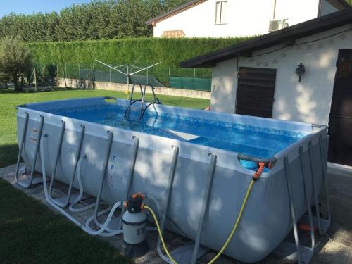 una piscina con una manguera pegada a una casa en Ca' Marsari, en SantʼAngelo