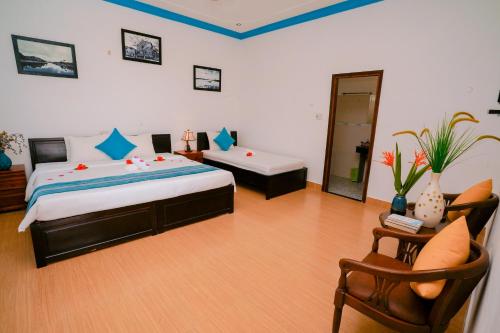 a large bedroom with a bed and a chair at Tra Que Green Villa Hoi An in Hoi An