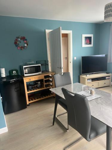 sala de estar con mesa, sillas y TV en 'Kodi's Place' Well appointed 1 bedroom apartment with excellent transport links and free Wi-Fi, en Whiteabbey