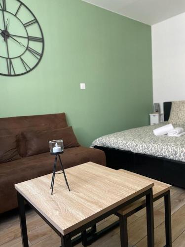 - un salon avec une table basse et une horloge murale dans l'établissement Studio moderne et tout équipé, à Bourges