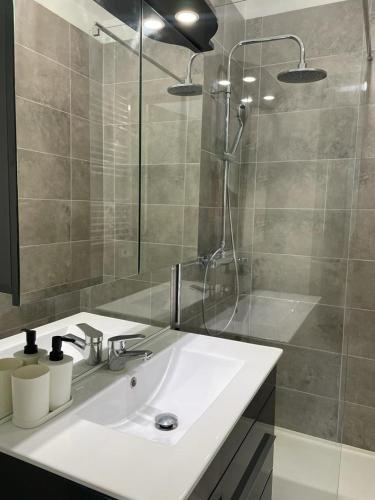 une salle de bain avec un lavabo blanc et une douche dans l'établissement Studio moderne et tout équipé, à Bourges