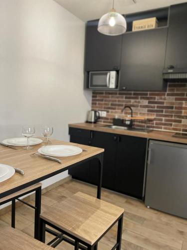 une cuisine avec une table, deux chaises et un comptoir dans l'établissement Studio moderne et tout équipé, à Bourges
