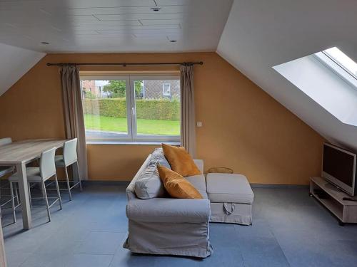 a living room with a couch and a table and a window at La Ferme Villa in Bastogne