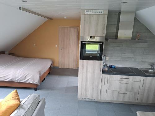 una cocina con fregadero y una cama en una habitación en La Ferme Villa, en Bastogne